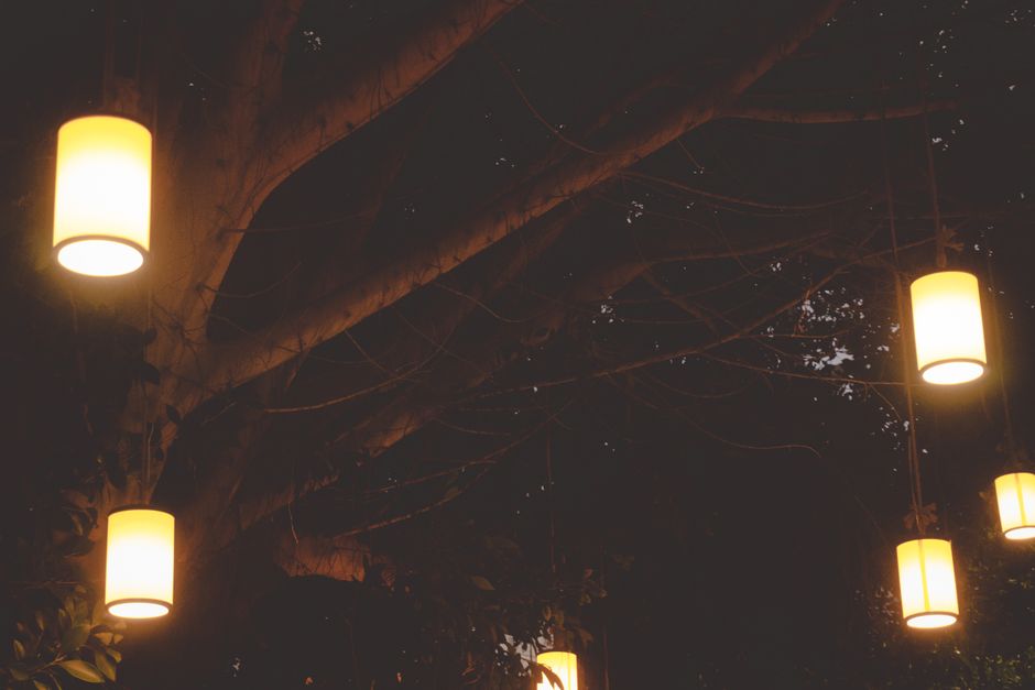 Hanglampen verlichten herfsttuin met warme gloed.