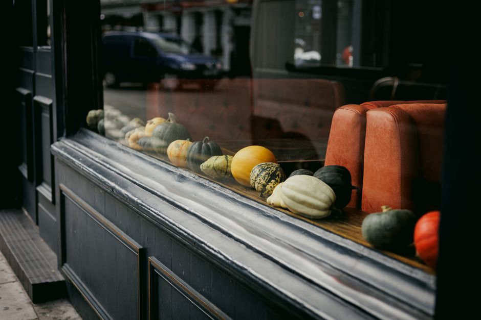 Autumn-themed wreaths adorn rustic window frames.